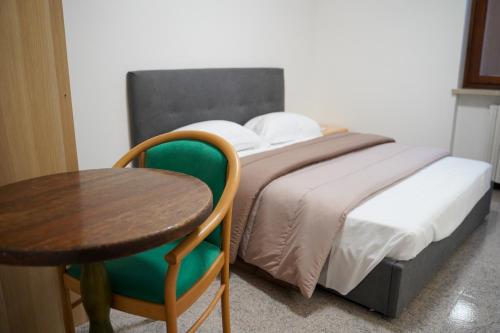 um quarto com uma cama com uma mesa e uma cadeira em Boccadoro Rooms em San Zeno