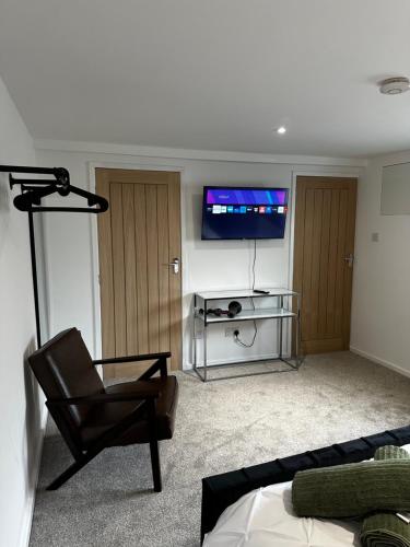 a living room with a chair and a flat screen tv at Entire Apartment super king bed close to Town Centre in Colchester