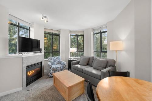 ein Wohnzimmer mit einem Sofa und einem Kamin in der Unterkunft Alpenglow Lodge Two Bedroom Apartment with Private Hot Tub by MVA in Whistler