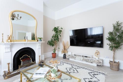 sala de estar con chimenea y TV en la pared en Stunning Large 4 Bedroom Victorian Home London en Londres