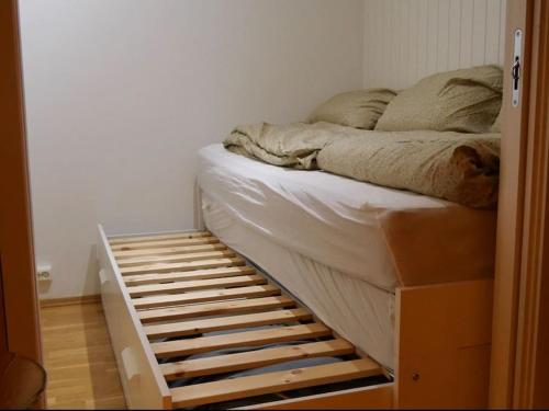 a bed in a room with a wooden bed frame at Lys og hyggelig leilighet, 3- roms på Solsiden in Trondheim