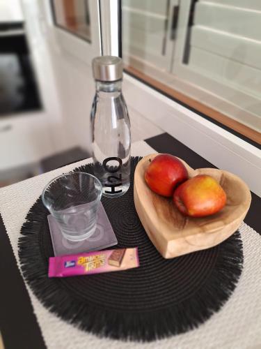 a bowl of apples and a bottle on a table at Apartamento a tan solo 2 minutos de la playa in Puerto del Rosario