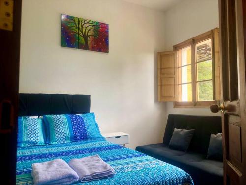 - une chambre avec un lit bleu et un canapé dans l'établissement Casa en la Candelaria con Gran Terraza Privada, à Bogotá