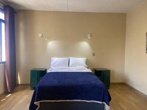 1 dormitorio con 1 cama grande con manta azul en Dpto en plena plaza principal en Tarija, en Tarija
