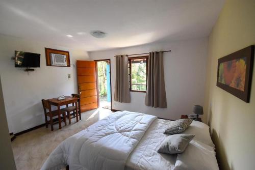 a bedroom with a bed and a desk and a window at Pousada Paris Hostelli in Penedo