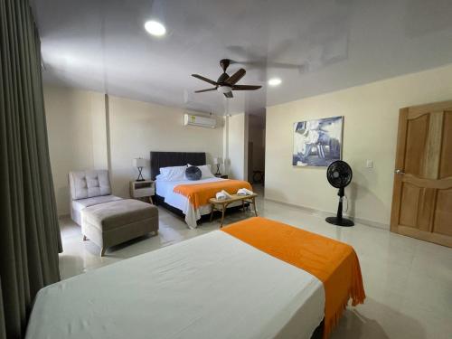 サン・アンドレスにあるAlka's Paradise Guest House and Lodgingのベッドルーム1室(ベッド2台、ファン、椅子付)