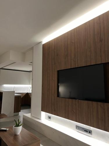 a large flat screen tv on a wall in a living room at Maison 49 Luxury Stay in Patra