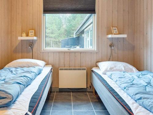 two beds in a room with a window at Holiday home Rømø XV in Bolilmark