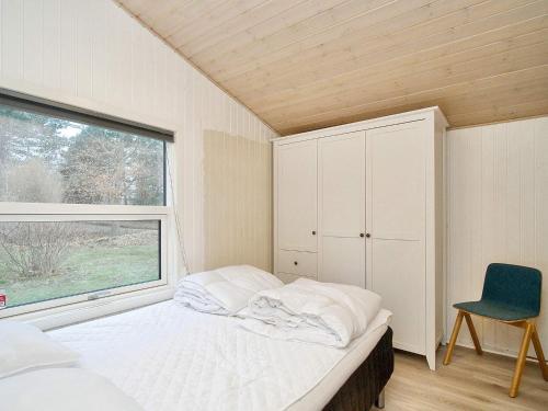 um pequeno quarto com uma cama e uma janela em Holiday home Gørlev IV em Gørlev