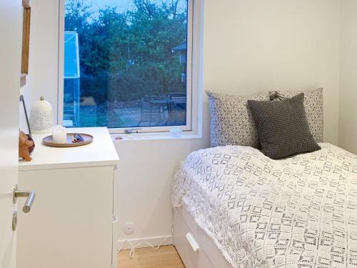 a bedroom with a bed and a window at Holiday home Stubbekøbing IV in Stubbekøbing