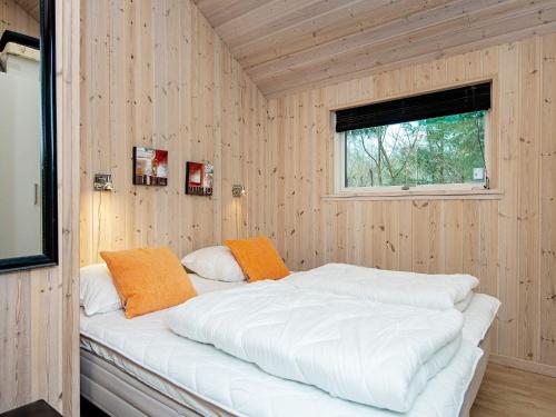 a bed in a room with wooden walls and a window at Three-Bedroom Holiday home in Silkeborg 3 in Dalsgårde