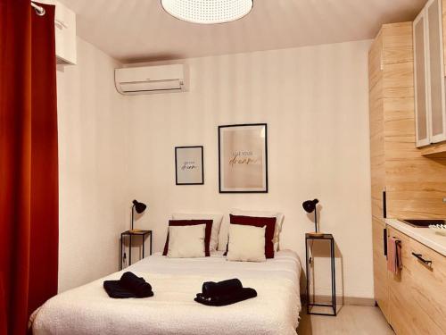 マンドリュー・ラ・ナプールにあるMARCO POLO - studio neuf avec parking & piscinesのベッドルーム1室(黒いタオル2枚付)