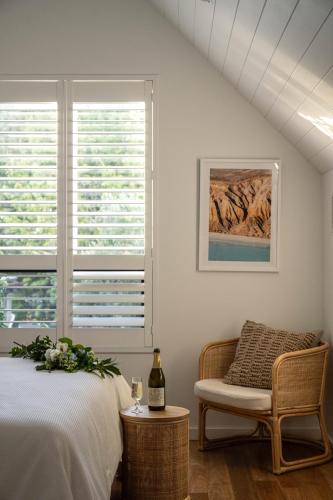 a bedroom with a bed and a chair and a window at Vale 194 - Luxury Accommodation in McLaren Vale - 5 holiday homes with king size beds in McLaren Vale
