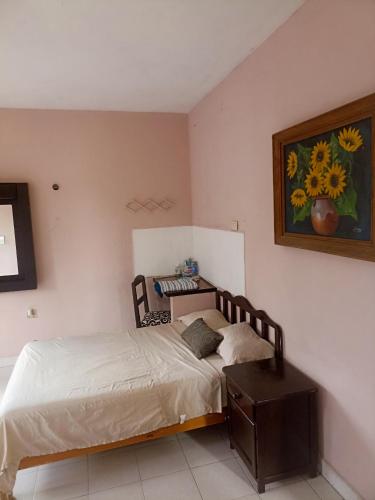 um quarto com uma cama e uma fotografia na parede em Apartamento en planta alta, a pie de calle em Cozumel