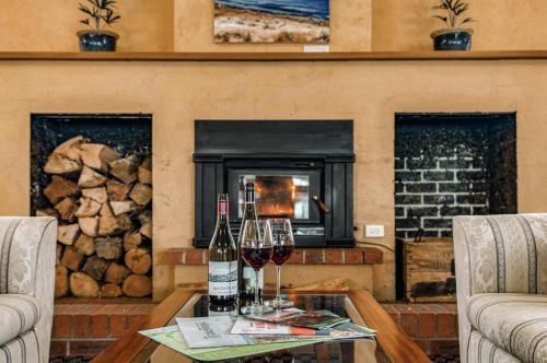a living room with a fireplace and wine glasses on a table at Panorama Hotel St Helens in St Helens