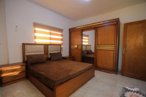 a bedroom with a large bed and a wooden door at Furnished apartment for rent in jarash شقة مفروشة للإيجار في جرش in Jerash