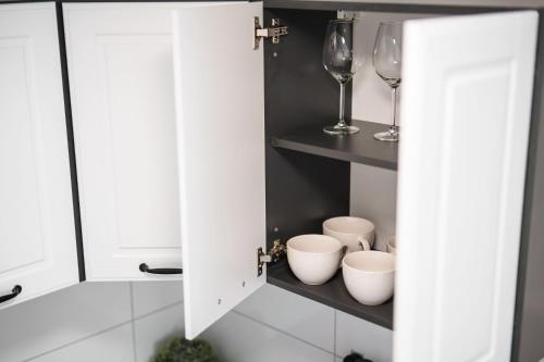 una cocina con un armario con copas de vino y tazones en Exklusive 1-Zimmer Stadtwohnung in Bremen, en Bremen