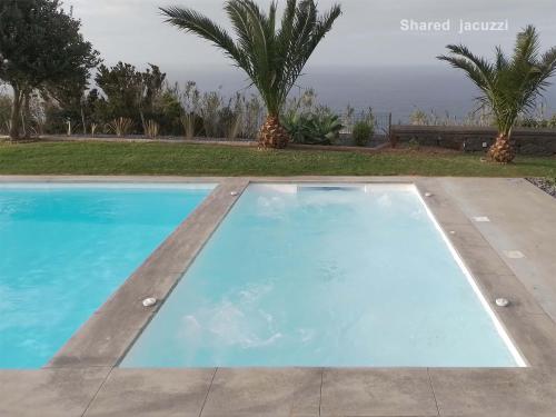 a swimming pool in a villa with a view of the ocean at Antiga Fábrica de Chá in Nordestinho