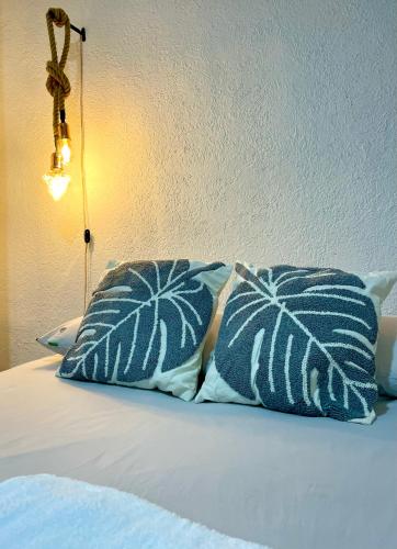 duas almofadas azuis e brancas sentadas numa cama em Apartaestudio Zona Norte - Vipasa em Cali
