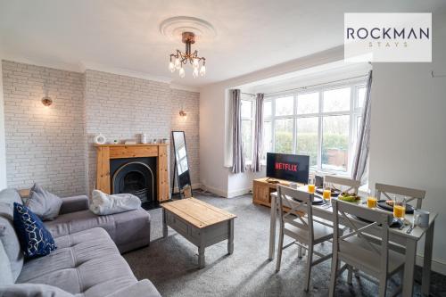 uma sala de estar com um sofá e uma mesa em Northumberland House 5 Bed Apartment Close To Beach with Parking by RockmanStays em Southend-on-Sea