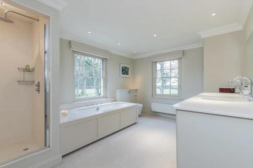 a large white bathroom with a tub and a sink at Isle Hill in Newbury