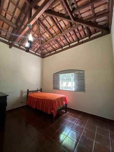 een slaapkamer met een bed in een kamer met een raam bij Sítio Paraíso Uberaba in Uberaba