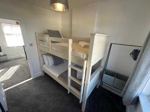 a room with two bunk beds with a mirror at Porth View Newquay in Saint Columb Minor