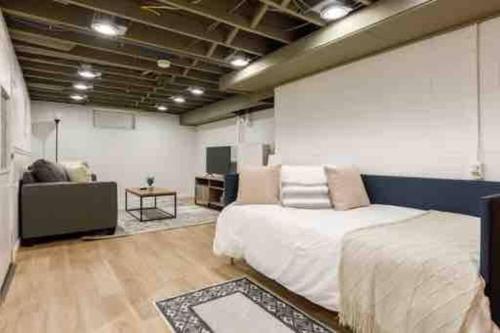 1 dormitorio con 1 cama grande y 1 sofá en Chic Modern Home: Private Yard & Hot Tub!, en Traverse City
