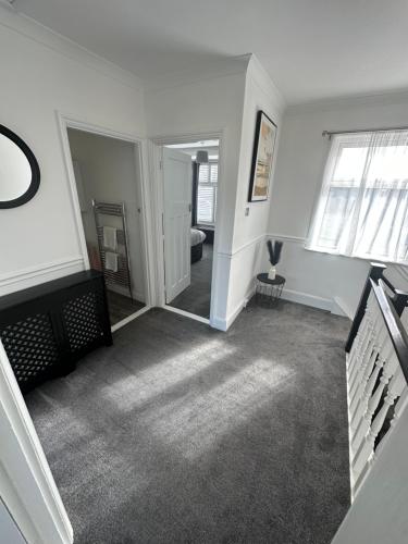 an empty living room with a mirror and a hallway at Porth View Newquay in Saint Columb Minor