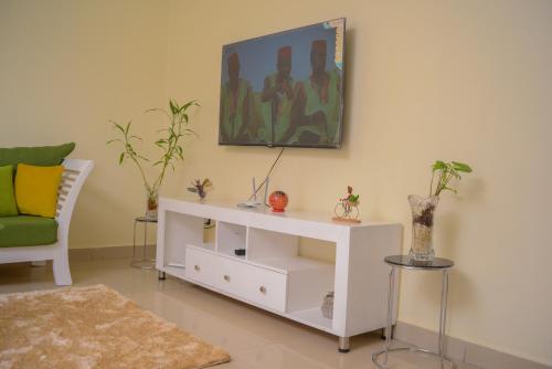 a living room with a white cabinet and a couch at RIMA 3BRM Cozy Apartment in Kampala