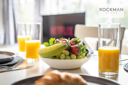 a bowl of fruit on a table with orange juice at 5 Bed Apartment Close To Beach with Off-street parking - Perfect for Contractors - Fast Wi-Fi - Close to beach in Southend-on-Sea