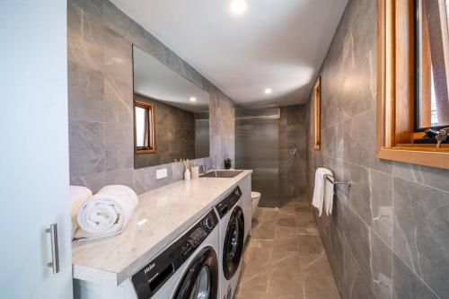 eine Waschküche mit Waschmaschine und Trockner in der Unterkunft Neptune - 2BR Private Pool WiFi in Thebarton