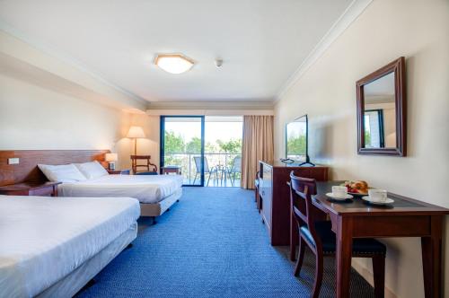 ein Hotelzimmer mit 2 Betten und einem Schreibtisch in der Unterkunft Panorama Hotel St Helens in St Helens