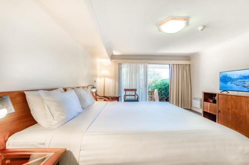 a bedroom with a large bed and a television at Panorama Hotel St Helens in St Helens