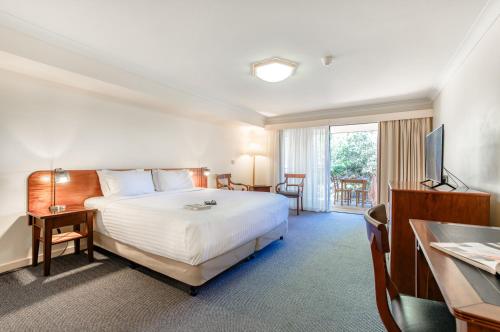 a hotel room with a bed and a television at Panorama Hotel St Helens in St Helens