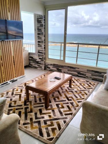 Sala de estar con mesa y vistas al océano en شقة بالإسكندرية علي البحر مباشر, en Alejandría