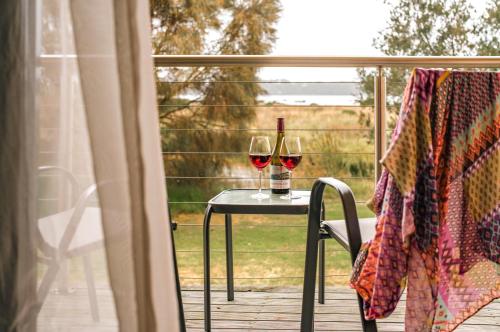 two glasses of wine sitting on a table on a porch at Panorama Hotel St Helens in St Helens