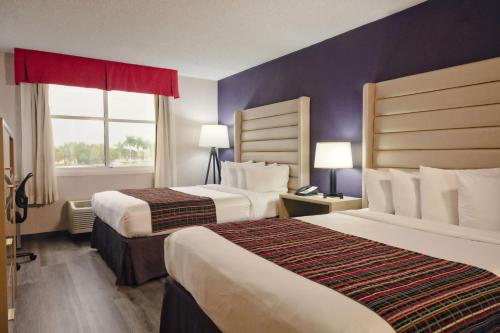 um quarto de hotel com duas camas e uma janela em The Palms Inn & Suites Miami, Kendall, FL em Kendall