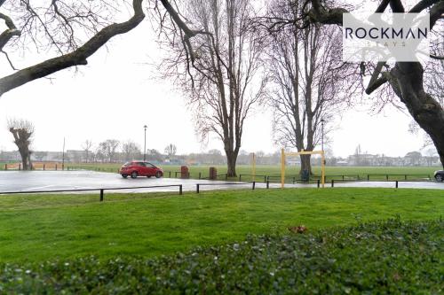 a red car driving down a road with trees at 5 Bed Apartment Close To Beach with Off-street parking - Perfect for Contractors - Fast Wi-Fi - Close to beach in Southend-on-Sea