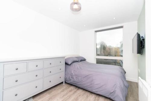 um quarto com uma cama, uma cómoda e uma janela em Modern, spacious entire 1 bedroom apartment. em Londres