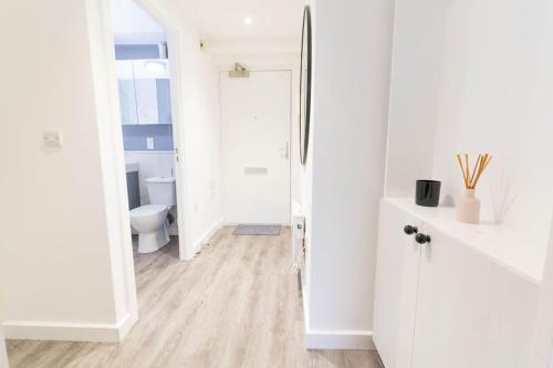 uma casa de banho branca com um WC e um espelho. em Modern, spacious entire 1 bedroom apartment. em Londres