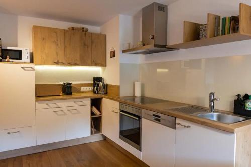 a kitchen with white cabinets and a sink at Gidnhof in Trins