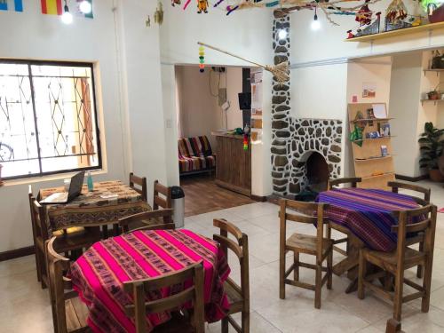 a room with a table and chairs and a fireplace at the weekend hostel in La Paz