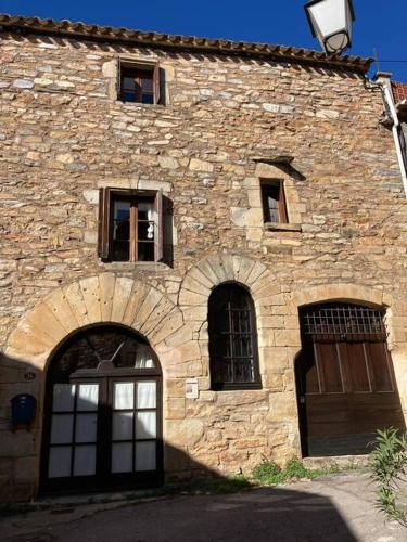 - un ancien bâtiment en pierre avec deux portes et fenêtres dans l'établissement 13th Century Stone House, à Faugères