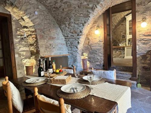 une salle à manger avec une table et un mur en pierre dans l'établissement 13th Century Stone House, à Faugères