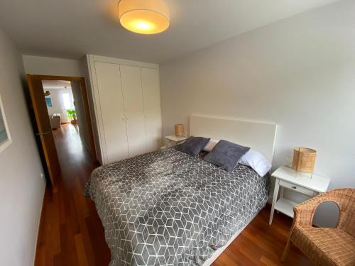 a bedroom with a bed with pillows on it at Piso Av Galicia playa in Finisterre