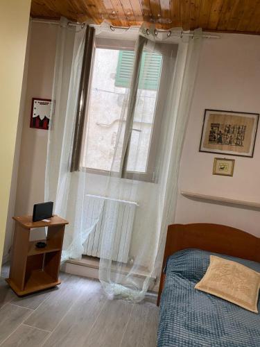 1 dormitorio con cama y ventana grande en Casa Borghellina, en Montaione