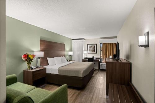 Quality Inn & Suites North Little Rock في نورث ليتل روك: غرفه فندقيه بسرير واريكه