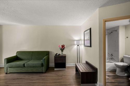 a living room with a green chair and a bathroom at Quality Inn & Suites North Little Rock in North Little Rock