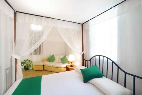 a bedroom with a bed and a couch in a room at Vihanga Village - Jungle retreat in Dambulla in Dambulla